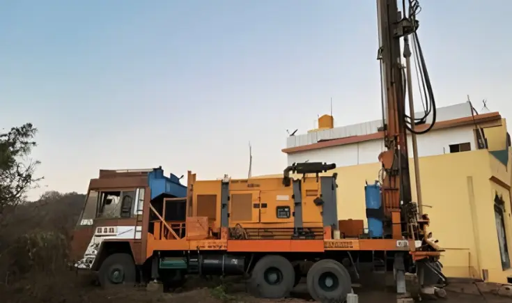 A drilling rig vehicle excavating a hole in a building's rainwater collection system