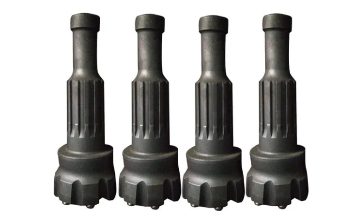 Four black drill bits on a white surface, symbolising best 4.5-inch borewell drilling services